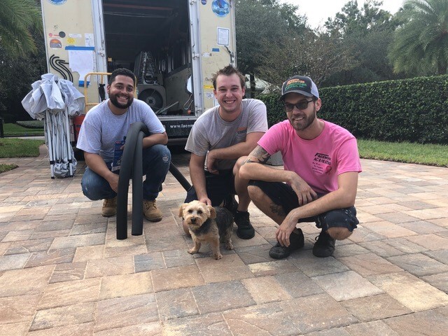 Technicians smiling with dog