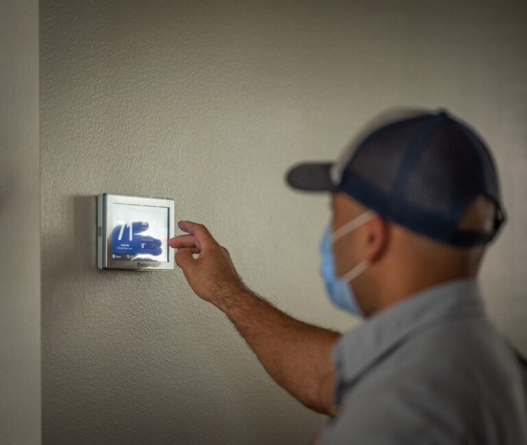 hvac tech working on thermostat