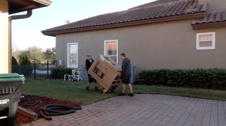 Technicians moving heat pump to home