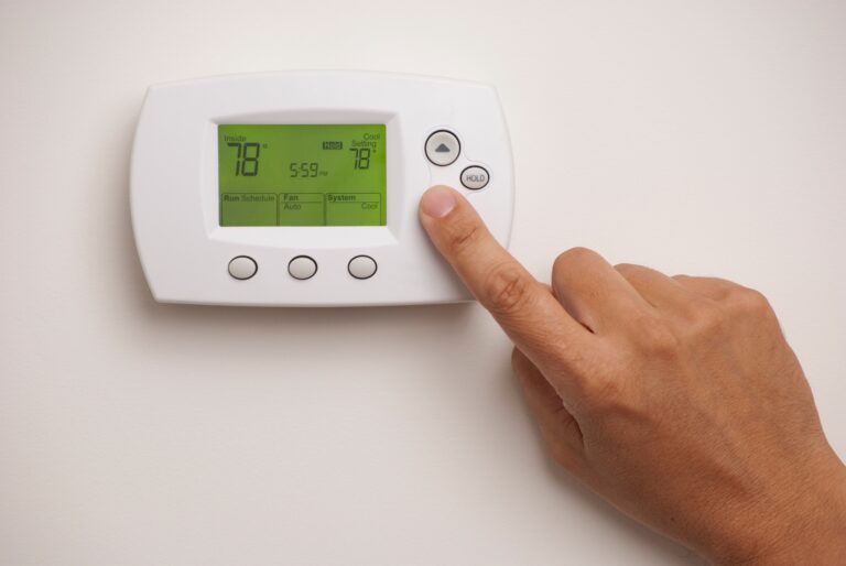 close up of hand setting thermostat